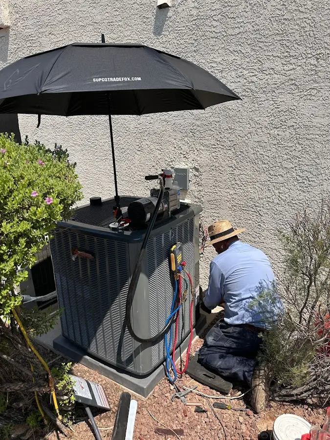 HVAC technician performing outdoor AC maintenance in Fife