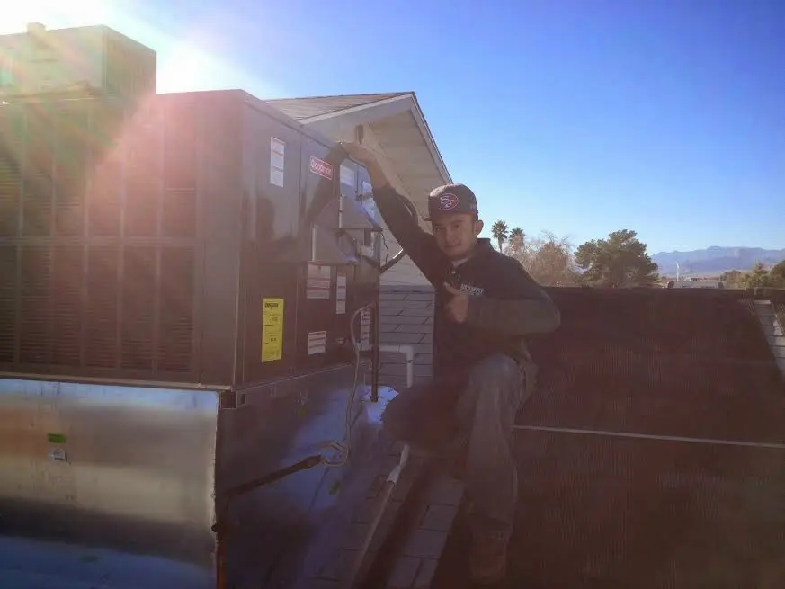 HVAC technician performing Boiler Repair on a rooftop unit in Fife